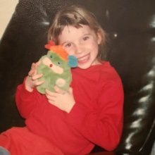 Caitlin as a child hugging a stuffed toy